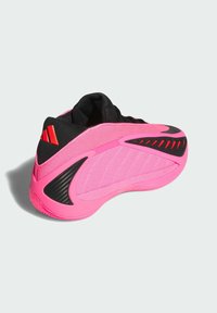 Ροζ αθλητικό παπούτσι με δίχτυ και συνθετικά υλικά, υφή σχεδίασης, μαύρες λεπτομέρειες και λεπτομέρεια τακουνιού που μοιάζει με ανθρακονήματα.