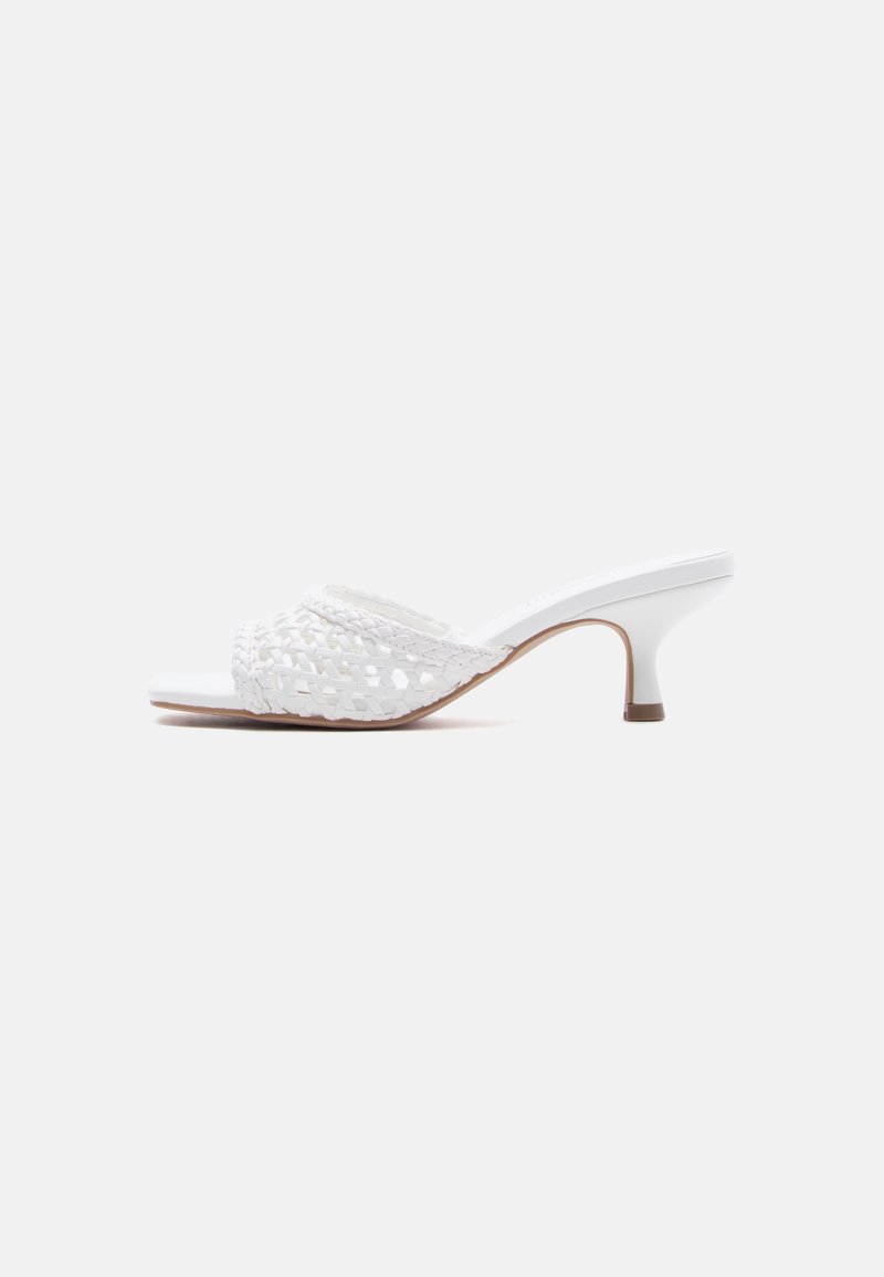 White mule sandal with woven front strap and slender mid-height heel, shown in profile on a plain background.