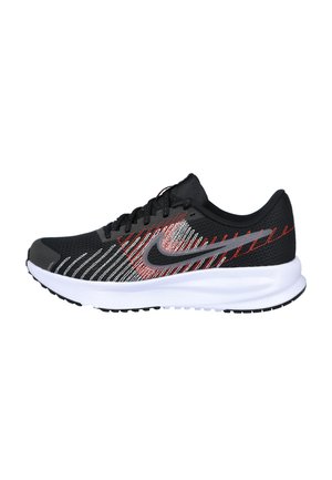 Zapatilla de correr en blanco y negro con detalles cosidos en rojo y blanco y un logo gris de Nike Swoosh en una suela blanca.