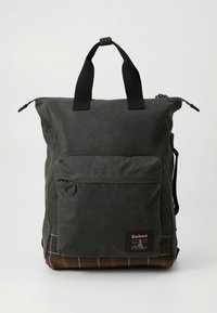 Dark green canvas backpack with adjustable black straps, exterior pocket, and plaid textile panel at the base. Features Barbour branding.