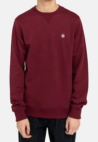 Felpa maroon con colletto e polsini a coste, caratterizzata da un piccolo logo sul petto, realizzata in morbido tessuto misto cotone.