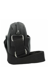 Borsa a tracolla nera in nylon con zip, tracolla regolabile, hardware in argento e tasca laterale, con un profilo compatto e arrotondato.