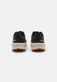 Black athletic shoes with a textile upper, cushioned sole, and rubber outsole. Features include a low profile and padded collar.
