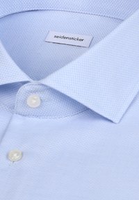 Light blue textured dress shirt with a spread collar, white buttons, and a "seidensticker" label inside the collar.