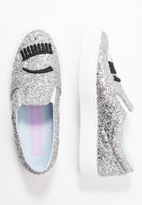 Silver glitter sandle med svart ögonfrans- och stängd ögonbrodering samt vita tjocka gummisulor, visade från ovan- och sidovy.