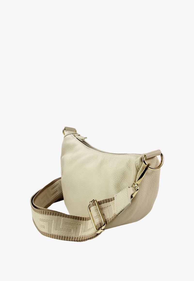 Sac à bandoulière en cuir crème avec une forme incurvée, une quincaillerie dorée et une bandoulière en tissu réglable à motifs. Texture lisse avec des détails minimaux.