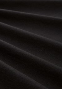 Zwarte stof met een gladde textuur, voorzien van zachte, golvende plooien en een egale kleur, geschikt voor diverse naai- of knutselprojecten.