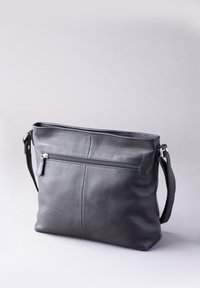 Black leather shoulder bag with a smooth texture, featuring a zippered outer pocket and an adjustable strap. Simple rectangular shape.