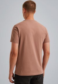 Krátký rukáv, tričko s kulatým výstřihem v světle hnědé barvě z bavlny, s hladkou texturou a standardním střihem, s viditelným šitím podél švů.