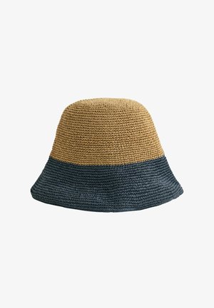 Tweekleurige geweven bucket hat met een beige bovenkant en een donkerblauwe rand, met een gestructureerd patroon en een zachte, flexibele structuur.