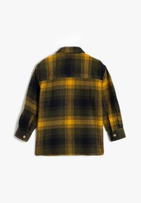 Camisa de franela a cuadros en verde oscuro, amarillo y azul marino. Cuenta con un collar puntiagudo, puños con botones y una textura suave. La parte trasera muestra el patrón de cuadros.