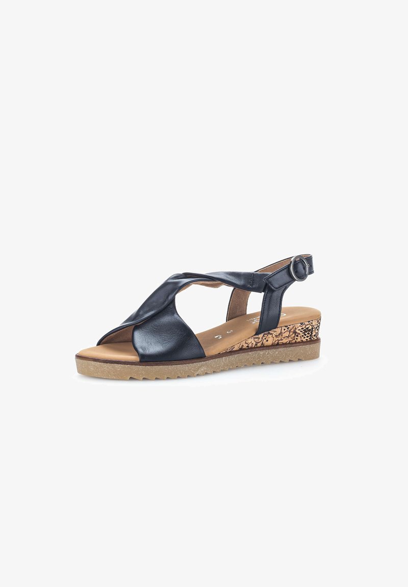 Sandale compensée en cuir noir à bout ouvert, avec brides croisées, boucle ajustable à la cheville, semelle texturée marron clair et talon compensé à motif.
