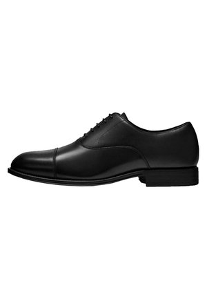 Schwarzer Herrenschuh aus Leder mit Kappzehe, Schnürverschluss und niedrigem Absatz, von der Außenseite vor weißem Hintergrund gezeigt.