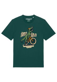 Grünes Baumwoll-T-Shirt mit einem Grafikmotiv eines Dinosauriers auf einem Fahrrad und dem Text "Fahre ein Fahrrad" sowie dekorativen Akzenten. Kurzarm.