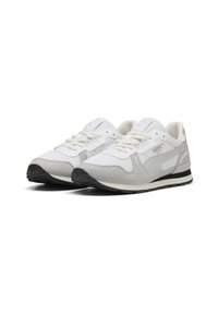 White sneaker with a textured upper, suede accents, and a black rubber sole. Features cream laces and a logo on the side.