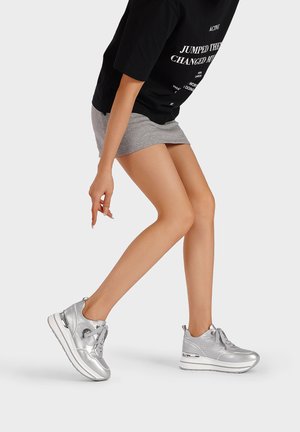 Scarpe da ginnastica argento con una superficie liscia e lucida. Presentano una punta arrotondata, un design con lacci e una suola ammortizzata per il comfort.