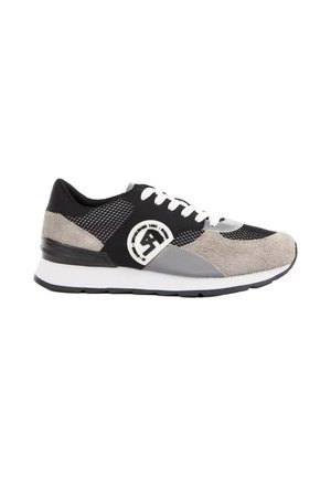 Zijaanzicht van een zwart-grijs-beige sportschoen met witte veters en een witte tussenzool op een witte achtergrond.
