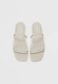 Grå flate sandaler med glatt overflate, med to slanke stropper og design med firkantet tå. Merking preget på fotsengen.