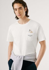 Witte katoenen t-shirt met korte mouwen, met een bulldog illustratie op de borstzak en de tekst "PEPE JEANS LONDON" eronder.