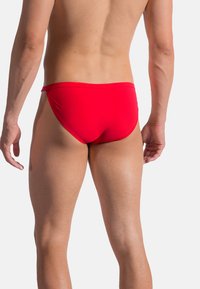 Röda simbyxor med en snug passform, tillverkade av slät tyg. Har en enkel design och en elastisk midja, vilket ger en minimalistisk look.