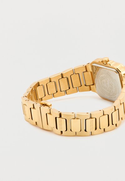 Χρυστό μεταλλικό μπρασελέ ρολογιού με ορθογώνιους συνδέσμους και μερικώς ορατή χαραγμένη πίσω όψη ρολογιού με σχέδιο κεφαλής Μέδουσας.