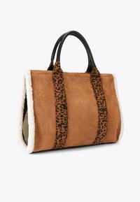 Borsa in tessuto marrone con motivo a onde, manici in pelle nera e spallacci con stampa leopardata. Rifinita con un bordo fluffy bianco e interno verde.