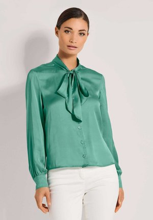 Groene satijnen blouse met een strikje op de hals, lange mouwen met knoopmanchetten en een knoopsluiting aan de voorkant. Glad textuur en lichtgewicht ontwerp.