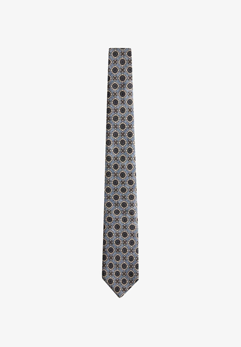 Cravate bleue avec motifs floraux circulaires répétitifs en noir, beige et bleu clair sur fond blanc.