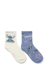 Dwie pary skarpetek typu crew: jedna biała z grafiką Stitcza i tekstem; druga jasnoniebieska z różnymi wzorami i kształtami Stitcza.
