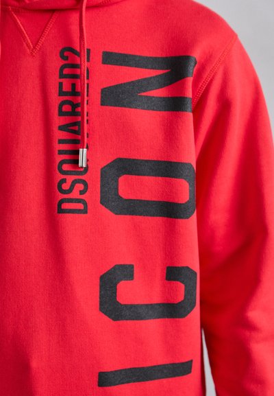 Sweat à capuche rouge en coton, présentant de grandes lettres noires imprimées disant "DSQUARED2 ICON" verticalement sur le côté gauche avec un détail de cordon de serrage.