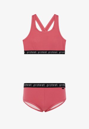 Roza sportska brusnica i odgovarajuće kratke hlače, obje s teksturiranim materijalom i crnim elastičnim pojasom s ponovljenim natpisom "protest".