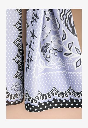 Jasnofioletowa tkanina z czarno-białymi kwiatowymi i geometrycznymi wzorami, falistymi krawędziami i detalem w postaci obramowania w kropki.