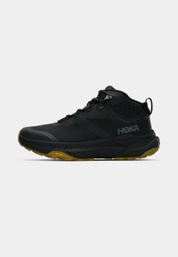 Juodas žygio batų modelis su tekstūruotu sintetiniu paviršiumi, guminis padas ir Vibram detalės. Turi sustiprintą pirštų dalį ir reguliuojamas raišteles.