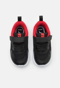 Scarpe per bambini nere con parte superiore in mesh, interno imbottito rosso, cinturino regolabile e suola in gomma bianca. Presenta il logo su etichetta rossa e insole.