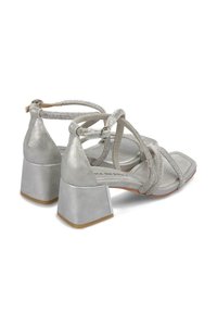 Sandali alti argentati con punta quadrata, dotati di cinturini metallici e tacco a blocco. Il design include dettagli testurizzati.