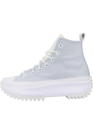 Zapatillas altas de cuero azul claro con suela de goma blanca. Las características incluyen ojales resistentes y una plataforma texturizada con bordes estriados.