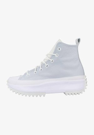 Zapatillas altas de cuero azul claro con suela de goma blanca. Las características incluyen ojales resistentes y una plataforma texturizada con bordes estriados.