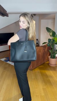 Borsa a tracolla nera in pelle con manici robusti, caratterizzata da una forma rettangolare, texture liscia e un'etichetta del marchio visibile.