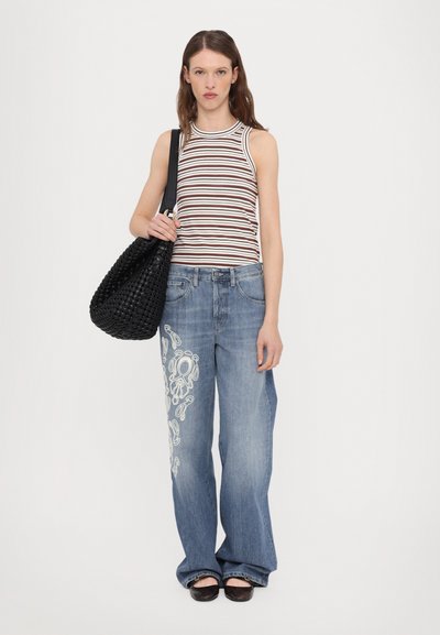 Striped tank top, blue wide-leg jeans with white embroidery, and a black woven handbag. Model wears black flat sandals.