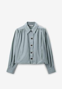 Chemise couleur bleu clair avec col, fermeture à boutons sur le devant, manches longues plissées et poches latérales. Fabriquée en tissu doux avec une texture lisse.