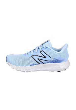 Zapatilla deportiva azul claro con parte superior de malla, suela blanca texturizada, logo negro "N" y cierre con cordones, mostrada de perfil lateral.