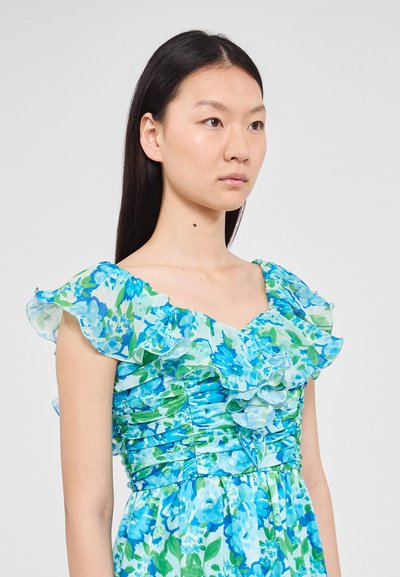 Robe florale aux teintes de bleu et de vert. Comprend des manches froncées et un corsage ajusté avec une texture plissée. Matériau léger.