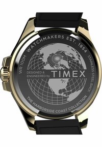 Montre Timex avec un fond en acier inoxydable, un bracelet en caoutchouc noir, un cadran rond et des accents dorés, présentant un design de carte du monde et un logo.