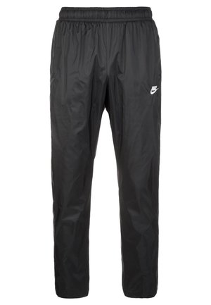 Mustat nylonista valmistetut urheiluhousut, joissa on joustava vyötärökaitale, löysä istuvuus ja pieni valkoinen Nike-logo oikealla reisillä.