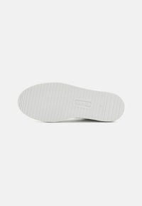 Soletta di scarpa con scanalature orizzontali, logo "Tamaris", taglia 37 e "Made in Portugal" impresso su sfondo bianco pulito.