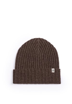 Brown ribbed knit beanie with folded cuff and small rectangular white logo tag on a white background.