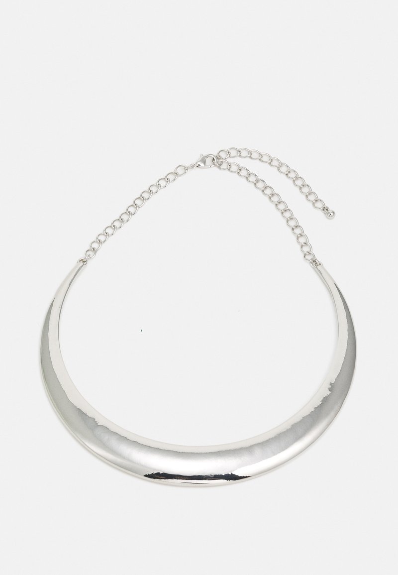 Collier ras du cou argenté en forme de croissant avec chaîne ajustable et fermoir mousqueton sur fond clair.