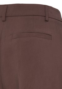 Pantalon en tissu marron montrant la ceinture arrière, les passants de ceinture et le détail d'une poche passepoilée simple sans fermeture visible.