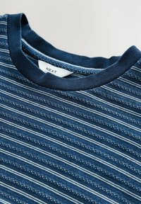 Camiseta de color azul marino con rayas horizontales en azul claro y blanco. Cuello redondo acanalado con etiqueta visible, textura de tela de algodón suave.