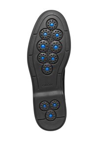 Suela de zapato negra con múltiples agujeros circulares, cada uno con acentos en azul. Superficie de goma texturizada para agarre y transpirabilidad. Modelo: GEox.